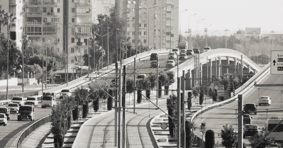 Urban scene with elevated roads and visible railway tracks amidst city buildings.